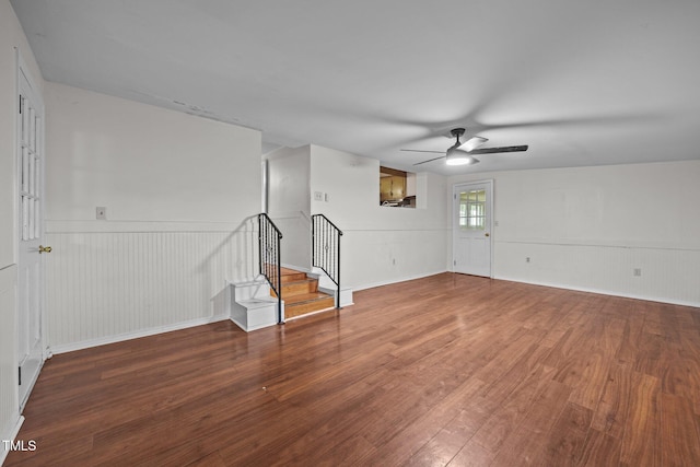 303 N Watauga Ave, Dunn, NC 28334 - unfurnished room with a ceiling fan, wood finished floors, stairway, and a wainscoted wall