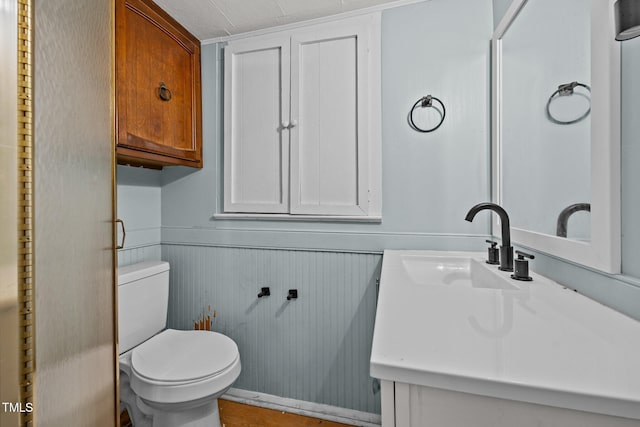 303 N Watauga Ave, Dunn, NC 28334 - bathroom featuring vanity, toilet, and a wainscoted wall