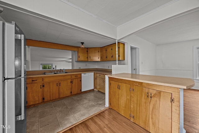 303 N Watauga Ave, Dunn, NC 28334 - kitchen featuring freestanding refrigerator, dishwasher, ornamental molding, a peninsula, and light countertops