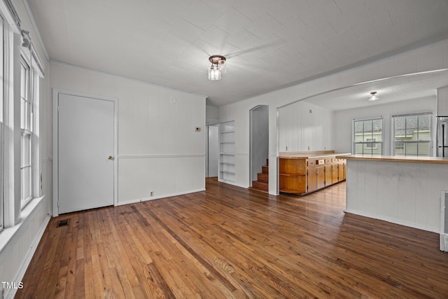 303 N Watauga Ave, Dunn, NC 28334 - unfurnished living room with arched walkways and hardwood / wood-style floors