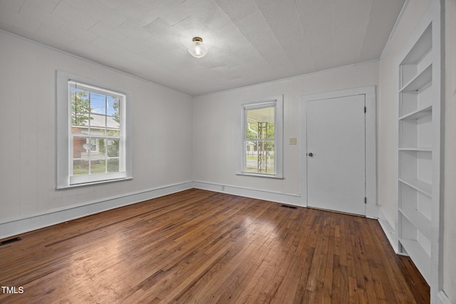 303 N Watauga Ave, Dunn, NC 28334 - unfurnished room with dark wood-style flooring and built in shelves