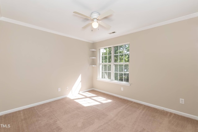 spare room with baseboards, ornamental molding, a ceiling fan, and carpet