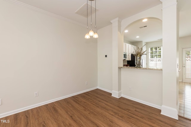unfurnished dining area with wood finished floors, baseboards, ornate columns, and recessed lighting