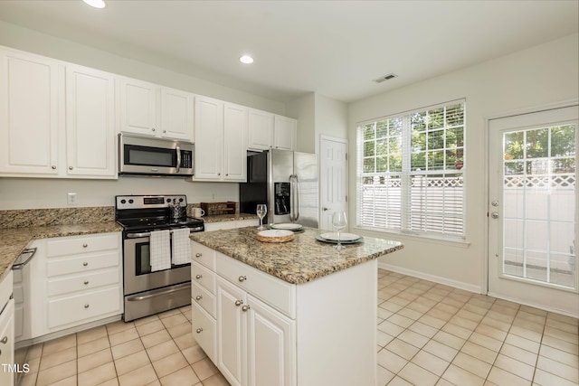 kitchen featuring stainless steel appliances, a kitchen island, light tile patterned floors, white cabinetry, and recessed lighting