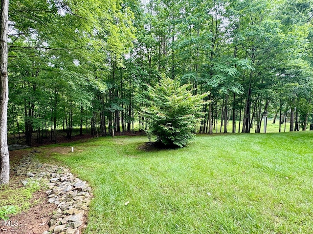 327 Beavertail Rd, Henderson, NC 27537 - view of grassy yard featuring a wooded view
