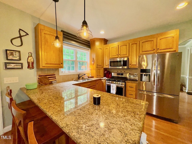 327 Beavertail Rd, Henderson, NC 27537 - kitchen featuring stainless steel appliances, a sink, light stone counters, tasteful backsplash, and a kitchen bar