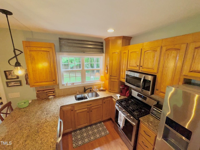 327 Beavertail Rd, Henderson, NC 27537 - kitchen with appliances with stainless steel finishes, a sink, wood finished floors, light stone countertops, and decorative backsplash