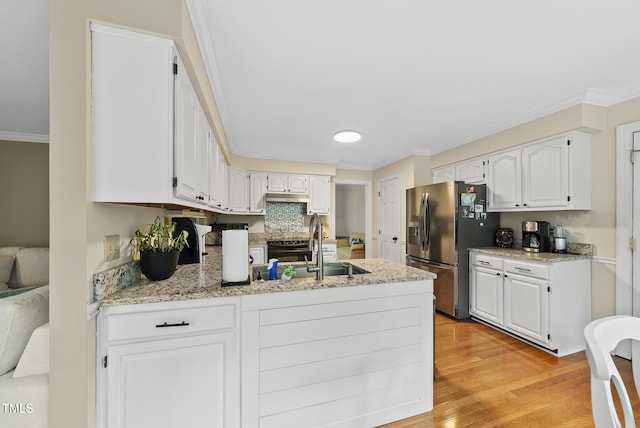 kitchen featuring stainless steel fridge, a peninsula, ornamental molding, white cabinets, and light wood-type flooring