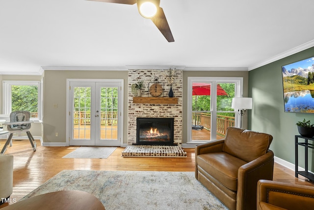 living room with a ceiling fan, hardwood / wood-style floors, crown molding, french doors, and baseboards