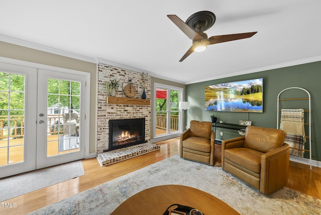 living room with crown molding, plenty of natural light, wood finished floors, french doors, and ceiling fan
