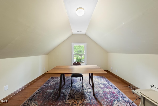 home office featuring lofted ceiling, wood finished floors, and baseboards