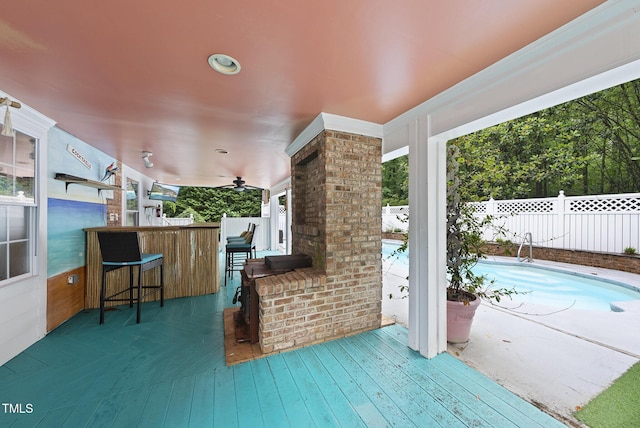 view of patio / terrace featuring a wooden deck, fence, and ceiling fan