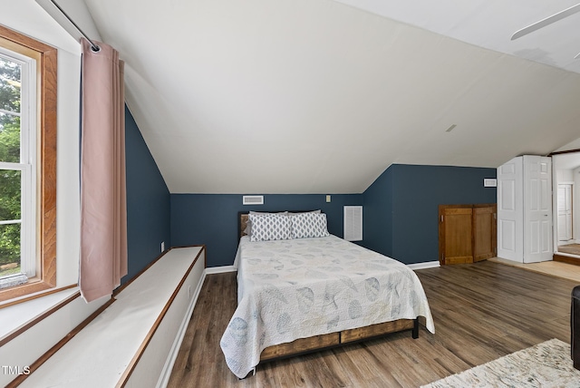 bedroom with lofted ceiling, wood finished floors, and baseboards