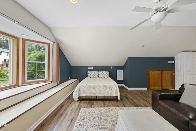 bedroom featuring lofted ceiling, wood finished floors, baseboards, and a ceiling fan
