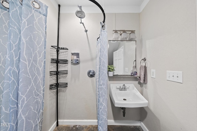 bathroom with baseboards, a sink, and a shower