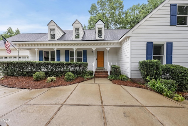 new england style home with a porch and a shingled roof