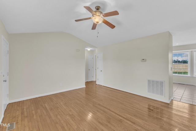 unfurnished living room featuring a ceiling fan, light wood-style flooring, lofted ceiling, and baseboards