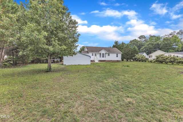 view of green lawn featuring an outbuilding