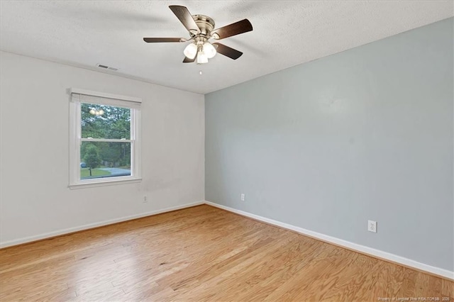 unfurnished room featuring light wood-style floors, baseboards, a ceiling fan, and a textured ceiling