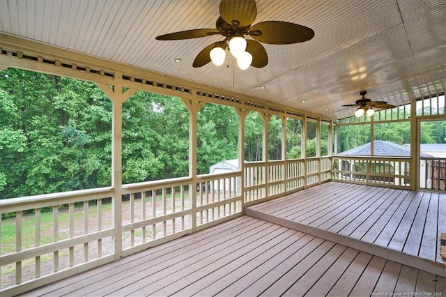 deck with a ceiling fan, an outbuilding, and a storage shed