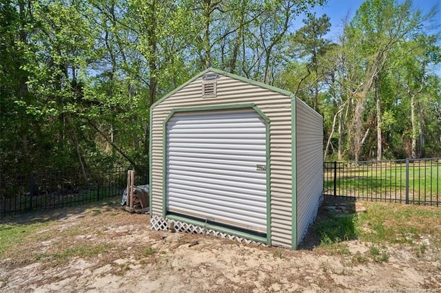 view of outdoor structure with fence and an outbuilding