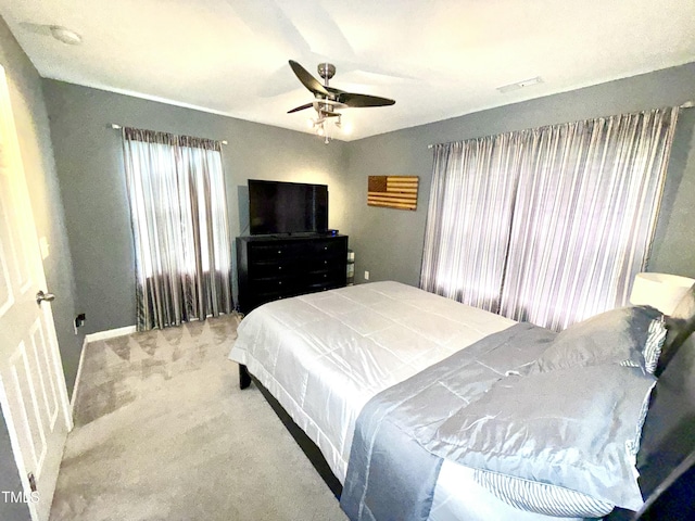 carpeted bedroom with baseboards and a ceiling fan