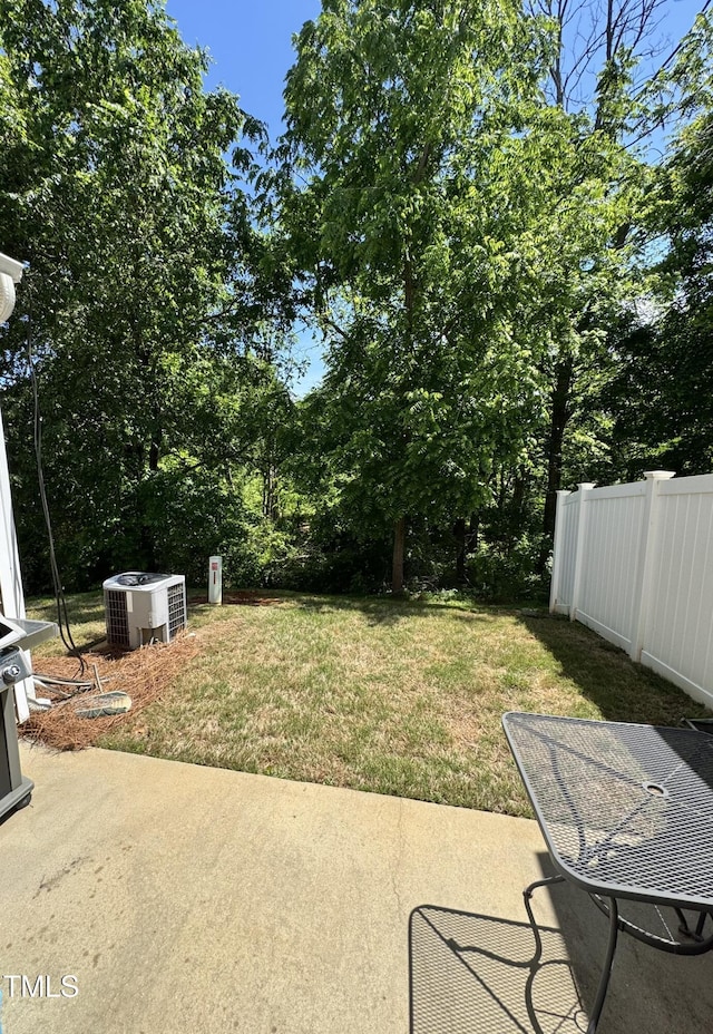 view of yard featuring a patio, central AC, and view of scattered trees
