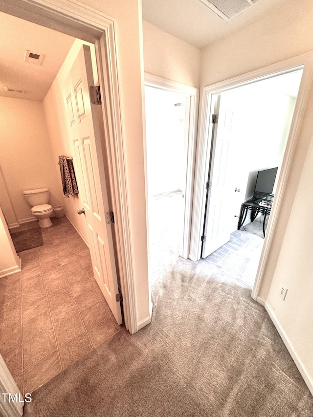 corridor featuring carpet and baseboards
