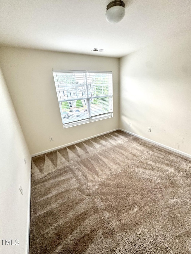 carpeted spare room featuring baseboards