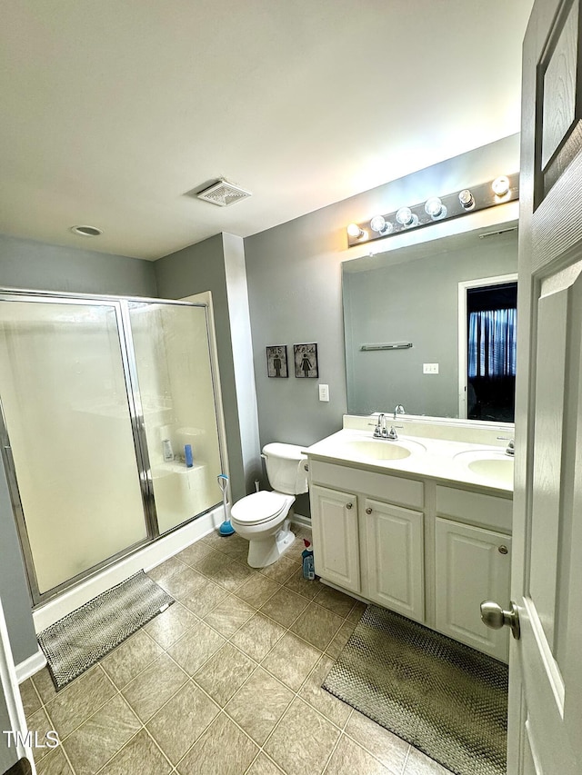 bathroom with a shower stall, double vanity, toilet, and tile patterned flooring