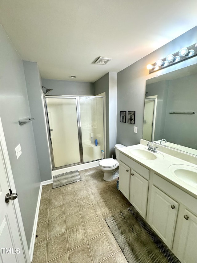 bathroom featuring a shower stall, double vanity, toilet, and tile patterned floors