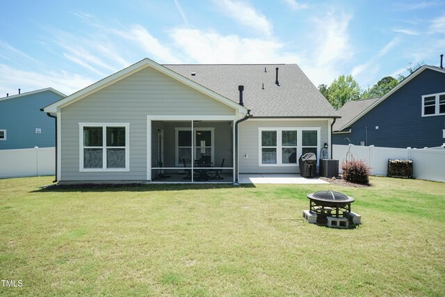 2501 Impulsion Dr, New Hill, NC 27562 - back of property with a fire pit, central AC unit, a sunroom, a shingled roof, and a patio
