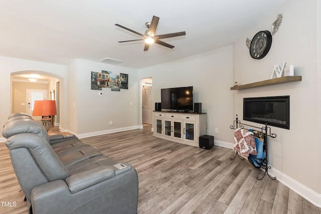 2501 Impulsion Dr, New Hill, NC 27562 - living area featuring ceiling fan, light wood-style flooring, arched walkways, and baseboards