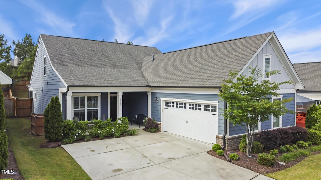 view of front of property with an attached garage, driveway, and roof with shingles