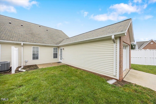 back of property featuring cooling unit, an attached garage, roof with shingles, and concrete driveway