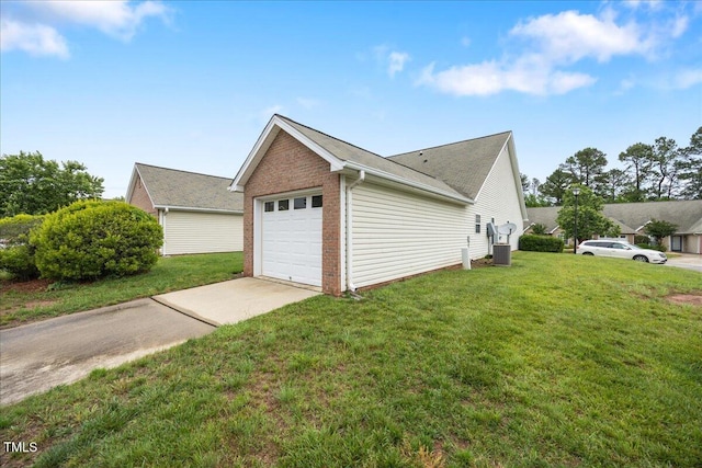 view of side of home featuring concrete driveway, a yard, brick siding, central AC unit, and an attached garage