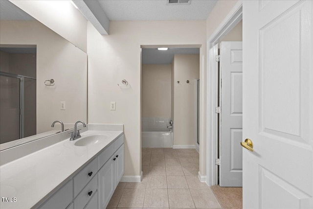 bathroom featuring tile patterned floors, baseboards, a stall shower, and vanity