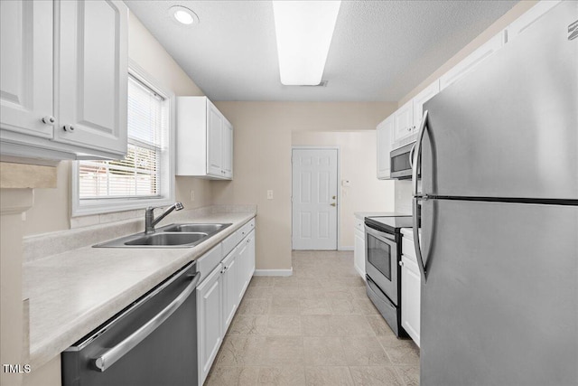 kitchen with appliances with stainless steel finishes, a sink, white cabinetry, a textured ceiling, and recessed lighting