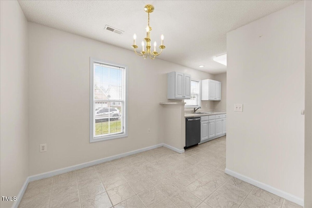 kitchen featuring dishwashing machine, a chandelier, light countertops, baseboards, and a textured ceiling