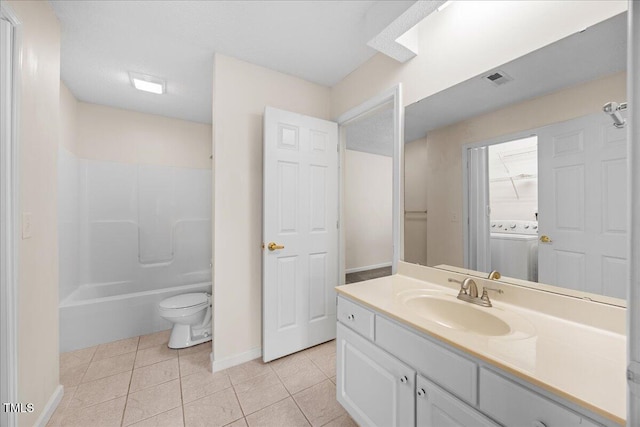 full bath with washer / dryer, tile patterned floors, baseboards, vanity, and toilet