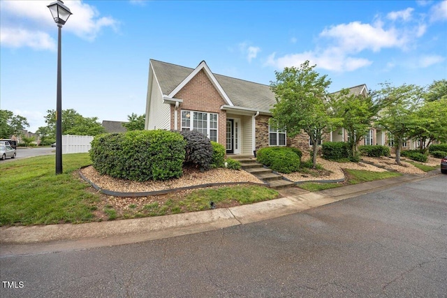view of front of property featuring a front lawn and brick siding