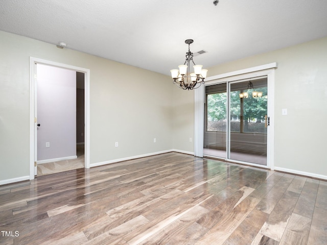 1911 Falls Landing Dr Unit 106, Raleigh, NC 27614 - spare room with a chandelier, wood finished floors, and baseboards