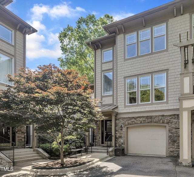 4802 Glenmist Ct, Raleigh, NC 27612 - view of front facade featuring a garage, stone siding, and asphalt driveway