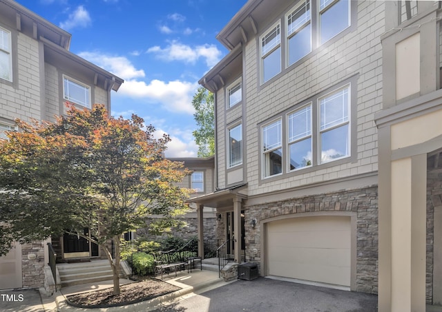 4802 Glenmist Ct, Raleigh, NC 27612 - view of front facade with stone siding, an attached garage, and asphalt driveway