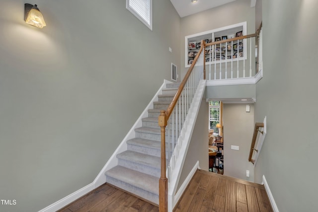 4802 Glenmist Ct, Raleigh, NC 27612 - stairway featuring wood finished floors, a towering ceiling, and baseboards