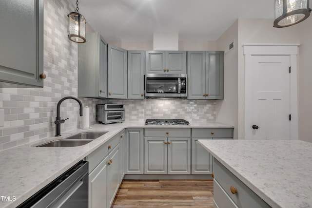 4802 Glenmist Ct, Raleigh, NC 27612 - kitchen with appliances with stainless steel finishes, gray cabinetry, a sink, and light stone countertops
