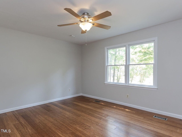 empty room featuring baseboards, dark wood finished floors, and ceiling fan