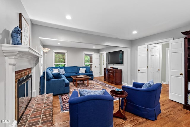 living area with recessed lighting, wood finished floors, a fireplace, and baseboards