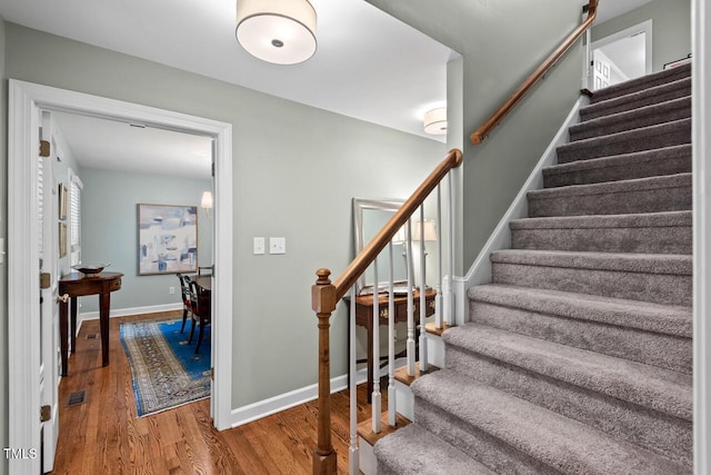 staircase with wood finished floors and baseboards