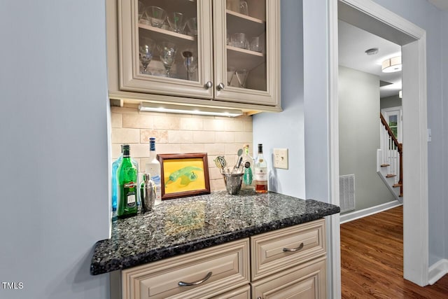 bar with backsplash, stairway, dark wood-style floors, and baseboards